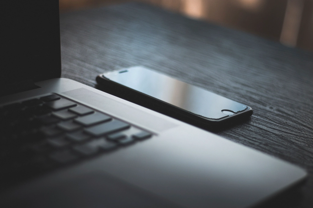 Un Mac y un iPhone sobre un escritorio de madera